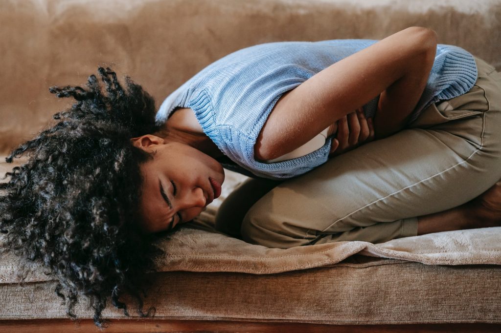 black woman in pain on sofa